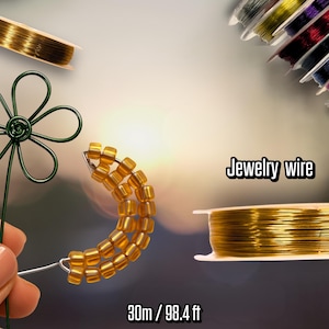 Può includere: Filo per gioielli in vari colori, tra cui bobine dorate e multicolori. Sono mostrati anche un fiore di filo verde e una mezzaluna di perline. La bobina di filo dorato è etichettata come 30 m / 98,4 piedi.
