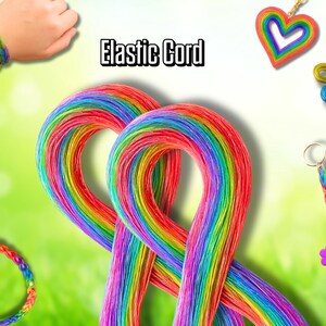 Op de afbeelding: Een levendige afbeelding met regenboogkleurig elastisch koord en diverse handgemaakte accessoires. De afbeelding toont armbanden, oorbellen, een hartvormige hanger en een bloemvormige sleutelhanger. De tekst "Elastic Cord" is zichtbaar. De accessoires zijn kleurrijk.