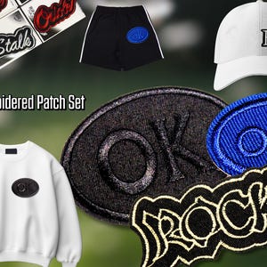 Op de afbeelding: Een geborduurde patchset met diverse ontwerpen, waaronder het woord "Rock", het woord "OK" in een ovaal en een witte baseballcap met het logo "The Beatles". Ook afgebeeld zijn zwarte shorts met een blauwe patch.
