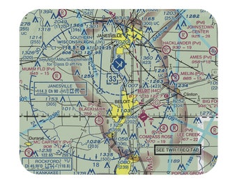 Puede incluir: Un gráfico aeronáutico con fondo verde y líneas negras que muestran la ubicación de aeropuertos y aeródromos en Wisconsin. El gráfico incluye los nombres de los aeropuertos, su elevación y la longitud de sus pistas. El gráfico también incluye la ubicación de varias ayudas a la navegación, como VOR y NDB. El gráfico está titulado "See TWR FREQ TAB".