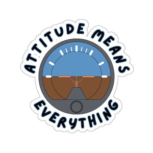 Puede incluir: Una pegatina blanca con un contorno negro y el texto "Attitude Means Everything" alrededor de un indicador de actitud gris y azul.