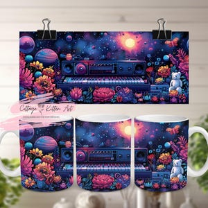 Op de afbeelding: Witte keramische mok en kunstdruk met een kleurrijk ontwerp van een keyboard, luidsprekers, planeten, bloemen en een teddybeer tegen een sterrenachtergrond. De kunstdruk wordt vastgehouden door zwarte clips. De tekst "Cottage & Kitten Art" is zichtbaar.