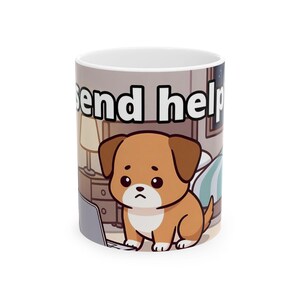 May include: White ceramic mug featuring a cartoon illustration of a sad-looking brown puppy sitting in front of a laptop. The mug has the words "send help" printed on it. The background shows a bedroom scene.