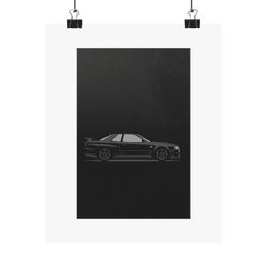 Könnte beinhalten: Ein schwarz-weißes Poster mit einer Seitenansicht eines Sportwagens. Das Auto hat einen Spoiler und detaillierte Felgen. Der Hintergrund ist einfarbig schwarz, und das Poster wird von zwei schwarzen Büroklammern gehalten.