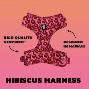 May include: Pink hibiscus print dog harness made of high quality neoprene. The harness is designed in Hawaii and features the text "Paws" in a white circle.