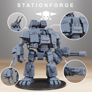 Op de afbeelding: Een grijs plastic model van een robot met een schedel en gekruiste beenderen logo op de borst. De robot heeft een groot geweer en een kleiner geweer op de arm. De robot staat op een grijze basis.