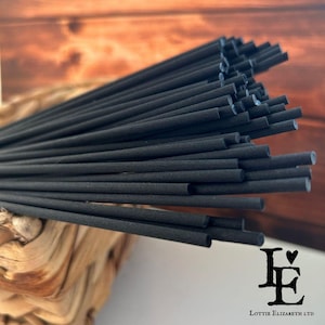 May include: A bundle of black incense sticks, arranged in a fan shape. The sticks are approximately 25 cm long and have a smooth, matt finish.