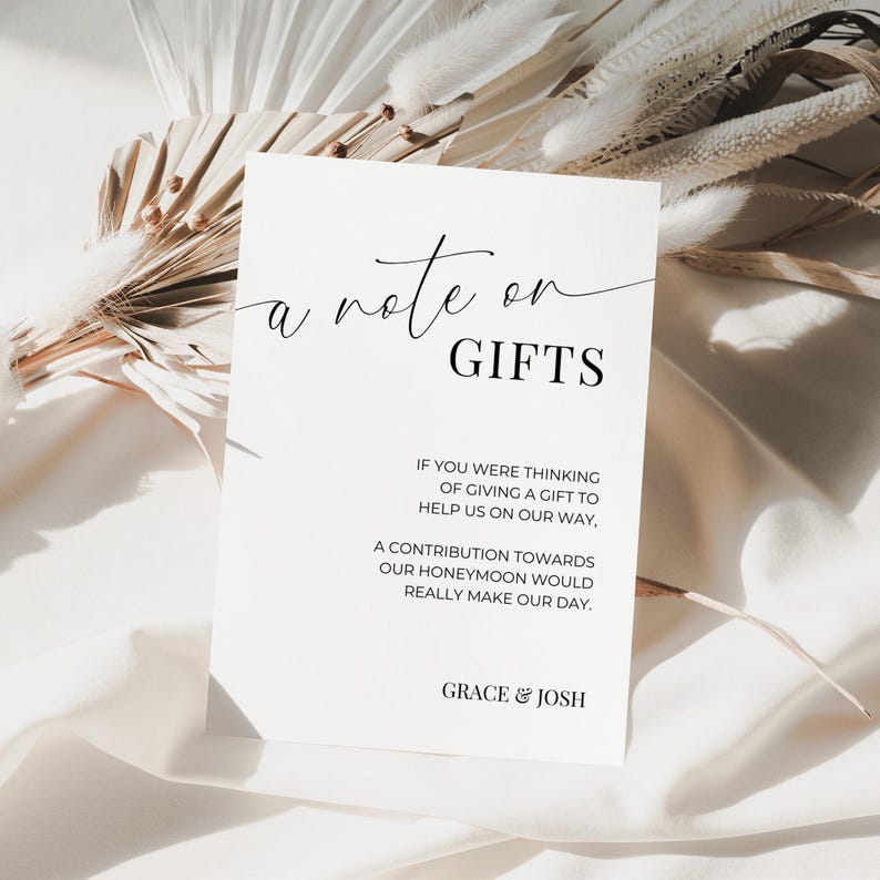 May include: A white card with black text that reads "a note on GIFTS" and includes the message "If you were thinking of giving a gift to help us on our way, a contribution towards our honeymoon would really make our day." The card is signed "GRACE & JOSH".