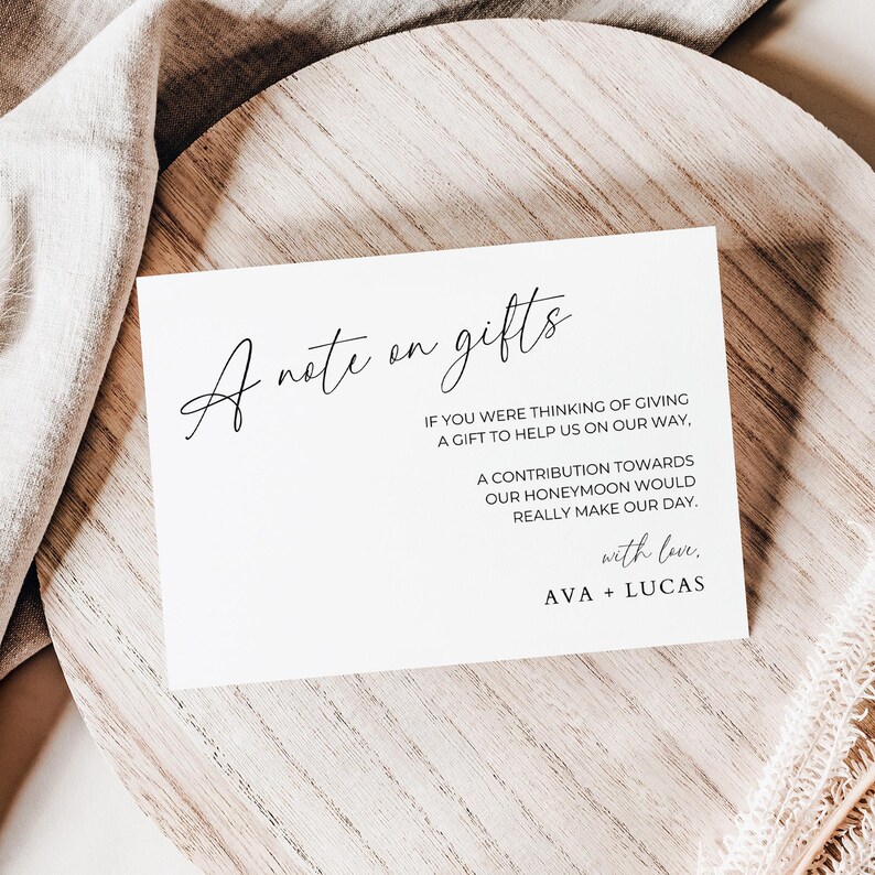 May include: A white card with black text that reads "A note on gifts". The text continues, "If you were thinking of giving a gift to help us on our way, a contribution towards our honeymoon would really make our day. With love, Ava + Lucas."