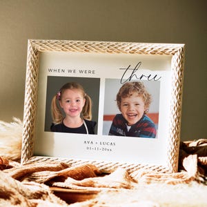 May include: A white picture frame with a beige mat and a white background. The frame has a woven pattern around the edge. The frame contains two photos of children, a girl and a boy, with the text "When we were three" above the photos and "Ava + Lucas 01-11-20xx" below the photos.