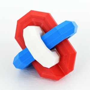 May include: A 3D-printed puzzle featuring interlocking geometric shapes in red, white, and blue. The puzzle has a central white piece that interlocks with a blue and a red piece, creating a visually engaging design. The pieces have a faceted surface.