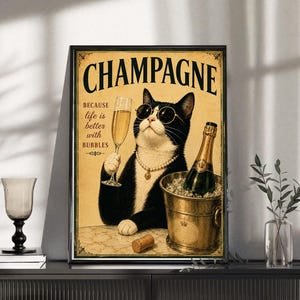 Könnte beinhalten: Ein gerahmtes Poster mit einer schwarz-weißen Katze, die eine runde Sonnenbrille und eine Perlenkette trägt und ein Champagnerglas hält. Der Text lautet CHAMPAGNE BECAUSE life is better with BUBBLES. Eine Flasche steht in einem Sektkühler.