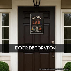 May include: A black rectangular sign with the text "WELCOME TO THE LAB" and the phrase "WHERE COOKING IS CHEMISTRY & CHANGE IS INEVITABLE." The sign features illustrations of lab equipment and a typewriter. The sign is mounted on a dark brown door.