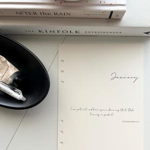 May include: A cream-colored planner page with a quote from Ecclesiastes 3:11, "I am patient and have peace knowing that God's timing is perfect." The page is titled "January" and has a hole punch on the left side.