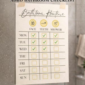 Puede incluir: Una lista de verificación de baño imprimible beige con el texto "ADHD BATHROOM CHECKLIST" en la parte superior. La lista de verificación incluye una sección de "Rutina de baño" con iconos de cara, dientes y ducha. Los días de la semana se enumeran verticalmente.