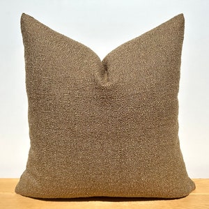 May include: A brown throw pillow with a textured fabric.