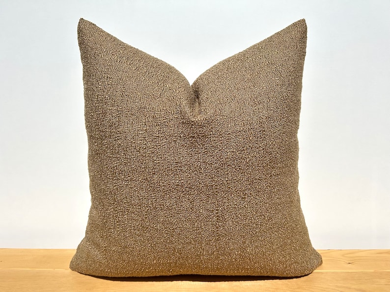 May include: A brown throw pillow with a textured fabric.