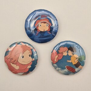 May include: Three round buttons featuring anime characters. One button shows a girl in a red hood in a blue background. Another shows a girl with red hair. The third button shows two characters kissing in a blue sky.