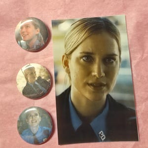 May include: Three circular pinback buttons and one rectangular print featuring a person with blonde hair wearing a light blue collared shirt with a dark jacket and a P.D. badge. The images show the same individual in various close-up angles.
