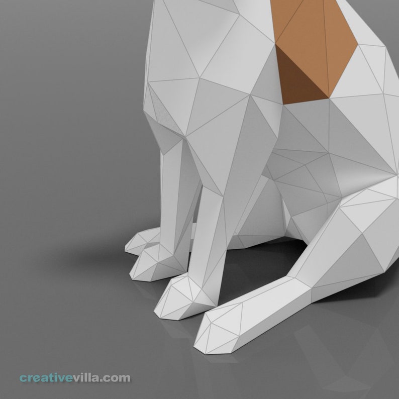 Pu&ograve; includere: Un modello di cane in origami di carta bianca seduto con le gambe piegate. Il cane ha una macchia marrone sulla schiena.