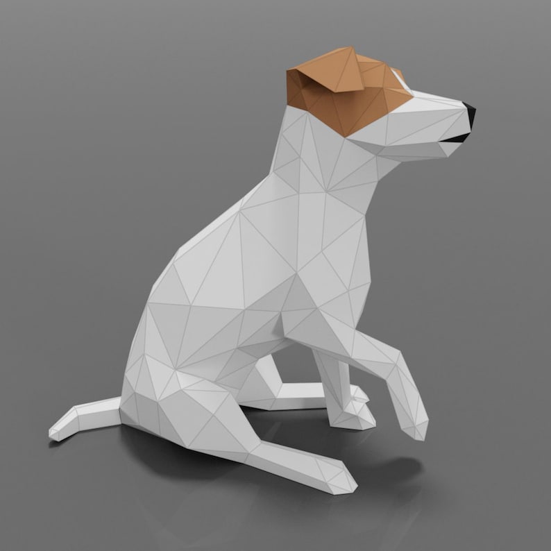Pu&ograve; includere: Un modello di cane Jack Russell Terrier in carta origami bianca seduto con la testa girata a destra. Il cane ha le orecchie marroni e il naso nero.