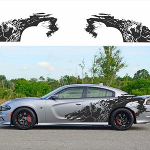 May include: A silver Dodge Charger with black and white graphic decals on the sides. The decals feature a stylised wolf howling at the moon with a grunge-style background.