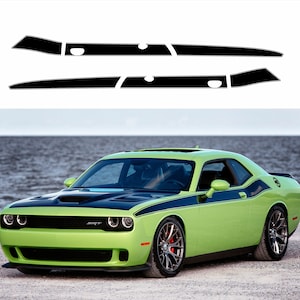 May include: A green Dodge Challenger SRT with black racing stripes and a black bonnet. The car is parked on a grey surface near a body of water.