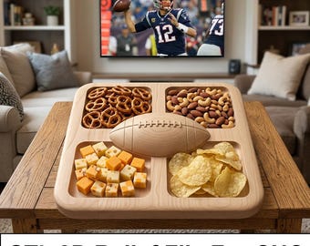 May include: A light-colored wooden serving tray featuring four square compartments and a central raised football shape. The tray is filled with pretzels, mixed nuts, cubed cheese, and potato chips. The text STL 3D Relief File For CNC is visible.