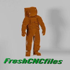 May include: A brown 3D printed astronaut figurine standing on a white background. The astronaut is wearing a spacesuit with a helmet and a backpack. The figurine is about 10 inches tall.