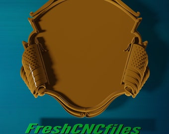 May include: A gold-colored, ornate, decorative plaque with a blank space in the center. The plaque is surrounded by two scrolls with a textured surface.
