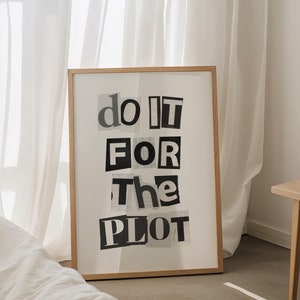 Puede incluir: Una impresión enmarcada con el texto "do it for the plot" en letras blancas y negras sobre un fondo blanco. El marco es de madera marrón claro.