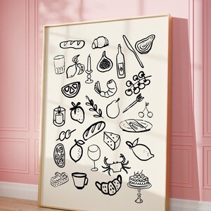 May include: A black and white illustration of various food and drink items, including lemons, grapes, bread, a crab, a shrimp, a pear, a fig, a candle, a wine bottle, a glass of wine, a cup, a cake, and a plate with cutlery. The illustration is on a white background and is framed in a gold frame.