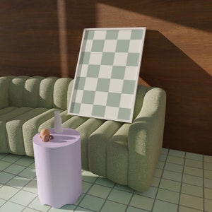 Puede incluir: Un sof&aacute; verde capiton&eacute; con un marco blanco con una imagen de un patr&oacute;n de cuadros verdes y blancos, una peque&ntilde;a mesa auxiliar morada con un jarr&oacute;n blanco y dos objetos redondos en la parte superior, y un suelo de baldosas.