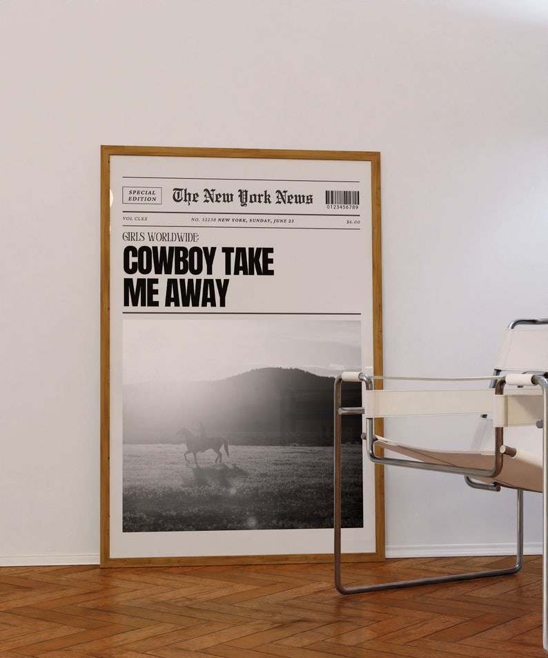 May include: A black and white photo of a person riding a horse in a field. The photo is framed and hanging on a white wall. The text "The New York News" is printed at the top of the photo. The text "GIRLS WORLDWIDE COWBOY TAKE ME AWAY" is printed below the photo.