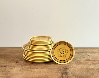 Una selección de platos llanos y de postre vintage amarillos con diseño de panal, en tamaños pequeño, mediano y grande, de Franciscan, Inglaterra, circa 1960.