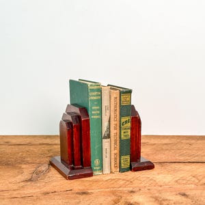 May include: A pair of dark red wooden bookends supporting four hardcover books. The books include titles such as Quantum Chemistry, Analytic Geometry, Mathematics for Technical Schools, and CRC Standard Math Tables with green and tan spines.
