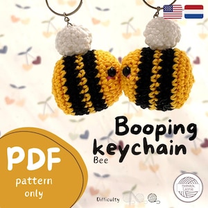 Puede incluir: Un patrón de llavero de abeja de crochet en formato PDF. El patrón incluye instrucciones para hacer una abeja linda, amarilla y negra con una cabeza blanca. El patrón está etiquetado como "Booping Keychain Bee" e incluye un nivel de dificultad.