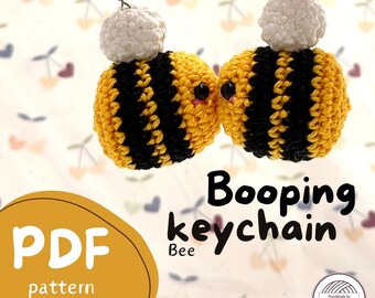 May include: A crochet bee keychain pattern in PDF format. The pattern includes instructions for making a cute, yellow and black bee with a white head. The pattern is labeled "Booping Keychain Bee" and includes a difficulty level.