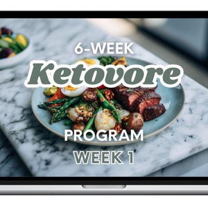 Könnte beinhalten: Ein Laptop-Bildschirm zeigt einen Teller mit Essen, darunter Steak, Spargel und Eier, mit der Aufschrift "6-WEEK Ketovore PROGRAM WEEK 1". Im Hintergrund befindet sich eine Schüssel mit Salat. Das Bild ist eine visuelle Anleitung für eine ketogene Diät.