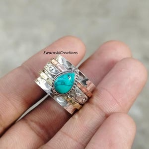 Peut inclure: Une bague tournante en argent avec une pierre turquoise et trois bandes en argent, or et cuivre.