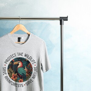 May include: Gray t-shirt with a circular graphic featuring a toucan, tropical plants, and the text "Protect the Wildlife Save Rainforests Save Nature".