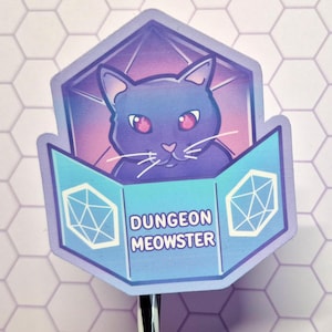 Könnte beinhalten: Ein Aufkleber mit einer Cartoon-Katze mit roten Augen in einer geometrischen Form. Die Katze befindet sich vor einem lila-rosa Farbverlauf. Der Aufkleber trägt den weißen Text "Dungeon Meowster" auf blauem Hintergrund.