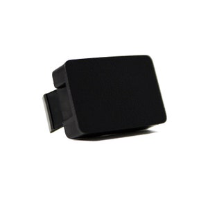 May include: A black plastic keycap for a keyboard.