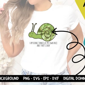 May include: A white t-shirt with a green snail illustration and the text "I am doing things at my own pace and that's okay."