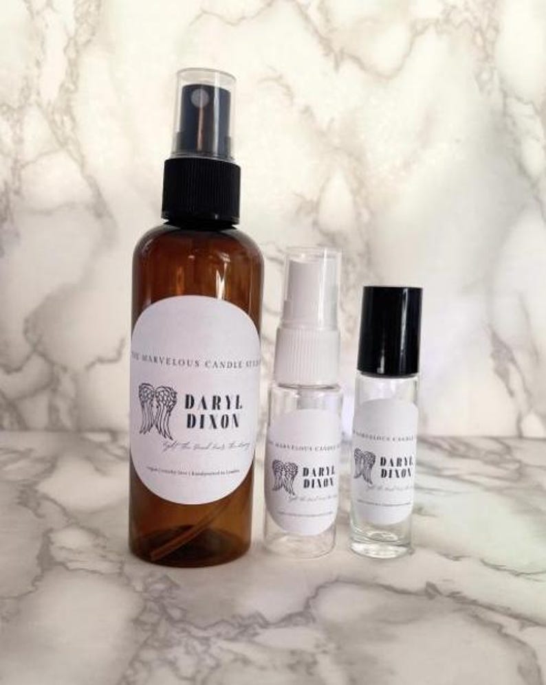 May include: Three glass bottles with spray tops and roll-on applicator. The bottles are labeled with the text "Daryl Dixon" and a pair of angel wings.