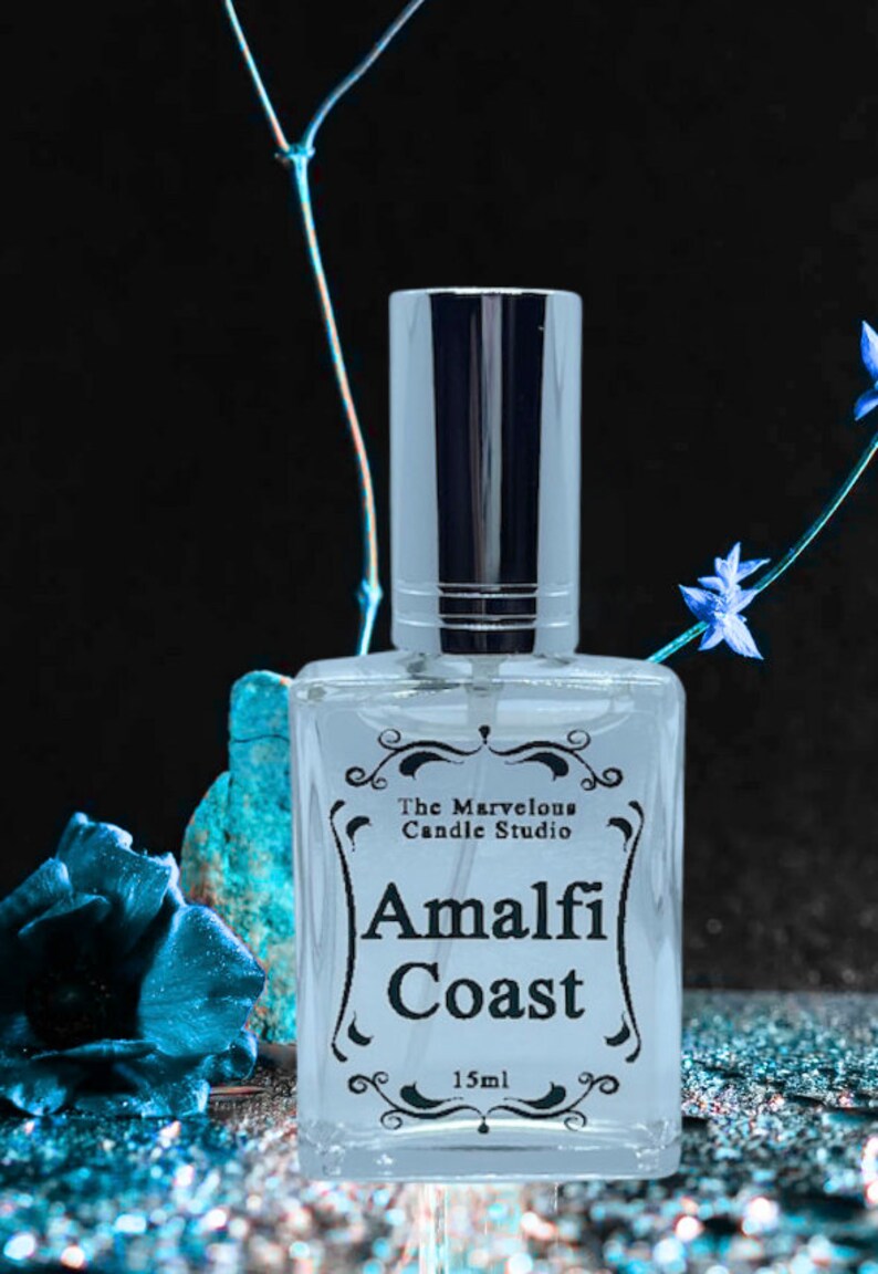 Puede incluir: Una botella de vidrio transparente con un pulverizador plateado y una etiqueta negra que dice "The Marvelous Candle Studio Amalfi Coast 15ml".