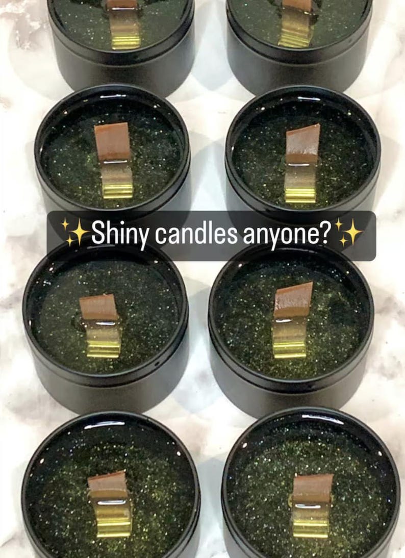 May include: Several black tins filled with a green, glittery substance and a wooden wick. The text "Shiny candles anyone?" is displayed on the image. The candles appear to be handmade.