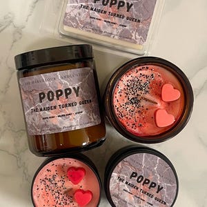 May include: An assortment of scented candles and wax melts from The Marvelous Candle Studio. The products feature the "Poppy" fragrance, with labels reading "The Maiden Turned Queen." The candles are in various containers, including a jar and tins, with decorative elements.