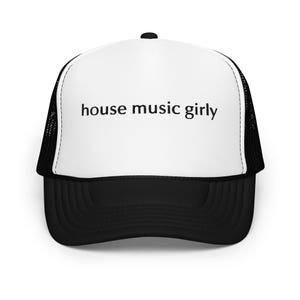 Op de afbeelding: Zwart-witte truckercap met een zwart mesh achterpaneel. De cap heeft de tekst "house music girly" op de voorkant gedrukt.