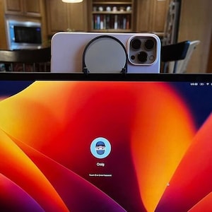 Könnte beinhalten: Ein silberner Laptop mit einer schwarzen Tastatur und einem leuchtend orangefarbenen, gelben und violetten abstrakten Hintergrund auf dem Bildschirm. Der Bildschirm zeigt einen Anmeldebildschirm mit dem Wort "Craig" und einem blauen Symbol einer Person mit einem blauen Hut.